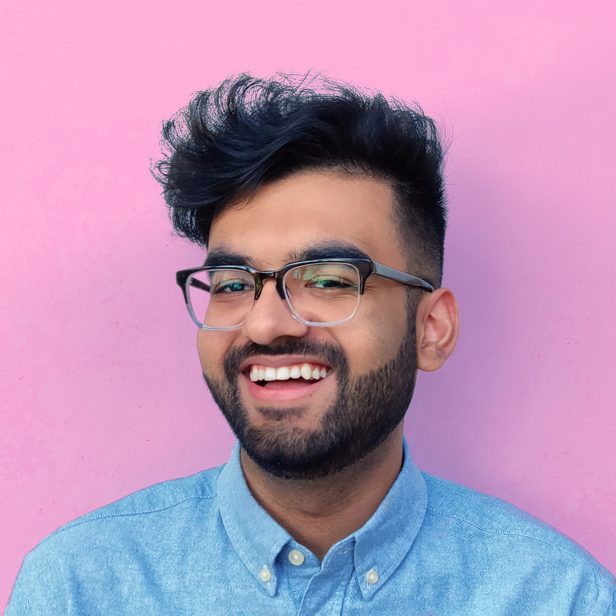 Zohaib standing in front of a bright pink wall