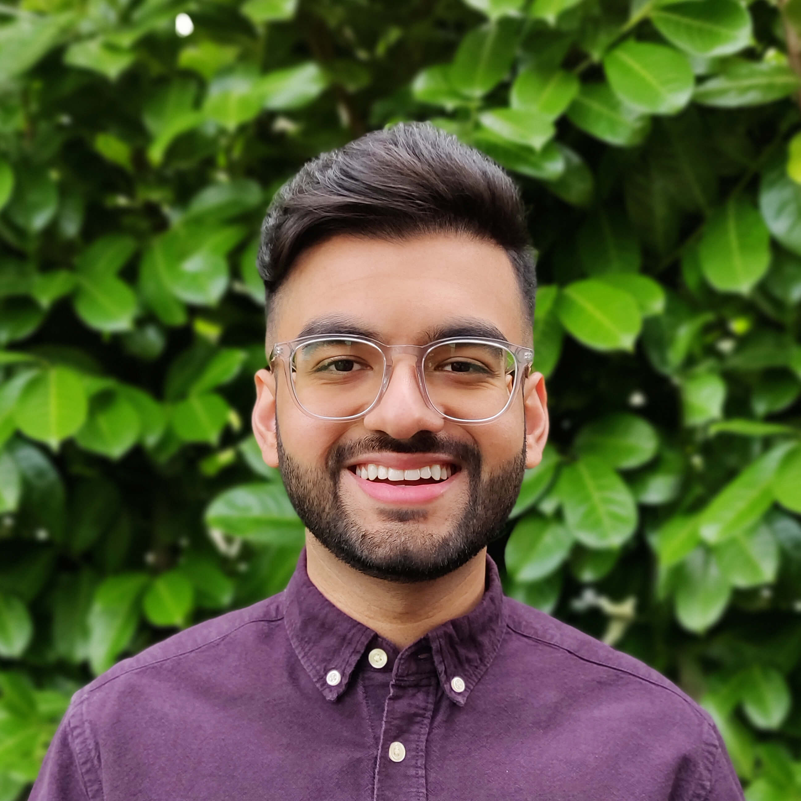 Zohaib standing in front of some luscious greenery
